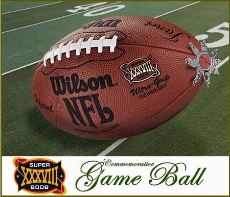 A Wilson NFL football labeled “Super Bowl XXXVIII” rests on a football field near the 50-yard line. The image includes a logo and text reading Commemorative Game Ball at the bottom. The tip of the ball has the same star nipple shield attached.